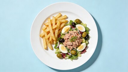 Crispy French Fries with Tuna Salad, Boiled Egg and Olives, Served on White Plate Against Light Blue Background (Balanced Meal Platter)