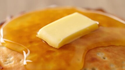 Macro shot of a melting piece of butter on the surface of a hot steaming pancake, a concept of simple gastronomic pleasure