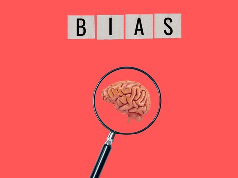 Words with bias on wooden blocks. bias. Individual viewpoints. preconceived notions. notion of prejudices and facts. magnifying glass with a representation of the brain	
