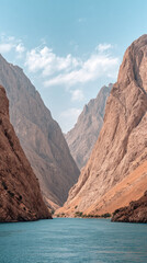 Towering canyon cliffs over turquoise river, serene sky