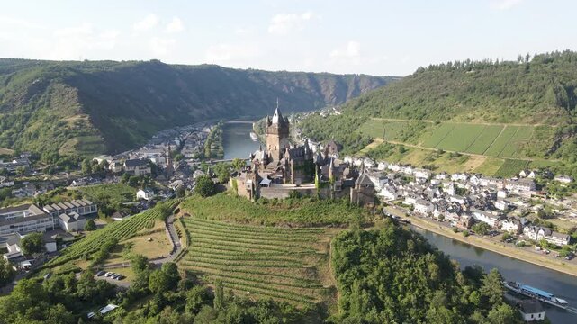 Drone shots of Reichsburg Cochem castle with the town and Moselle River in the background.