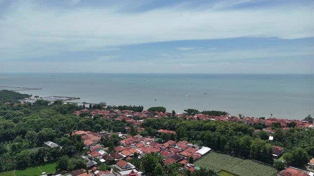 Aerial View of Tropical Coastal Village with Red Roofs and Blue Sea