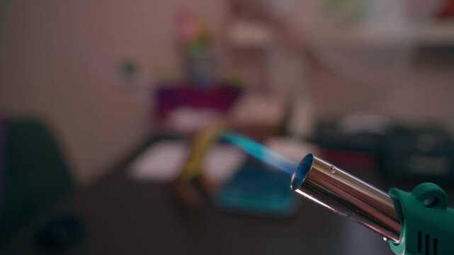 The process of igniting a butane torch in slow motion, close-up