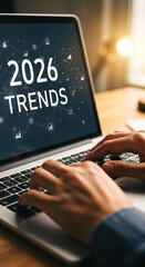 "Hands Typing on Laptop Keyboard with '2026 Trends' on Screen &mdash; Research and Market Analysis"
