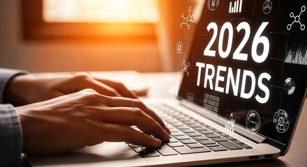"Hands Typing on Laptop Keyboard with '2026 Trends' on Screen &mdash; Research and Market Analysis"
