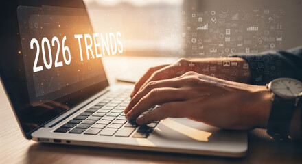 "Hands Typing on Laptop Keyboard with '2026 Trends' on Screen &mdash; Research and Market Analysis"
