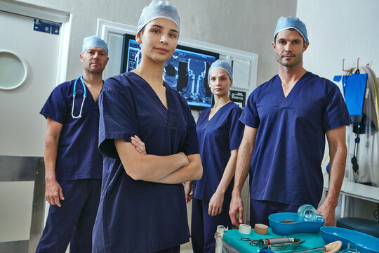 Surgery, xray and arms crossed with portrait of doctors in hospital for medical treatment, team and thyroidectomy. Healthcare, throat ct scan and about us with people in operating theater of clinic