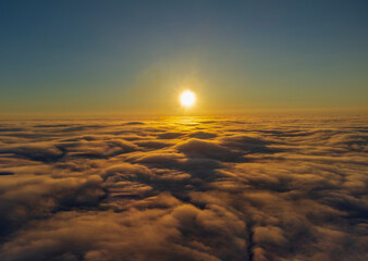 A stunning view of a sunrise or sunset from above the clouds. A breathtaking view of either a sunrise or a sunset taken from an aerial perspective above a thick layer of clouds