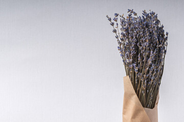 A bunch of lavender in craft paper on a light background with copy space.