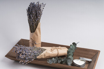 Wooden tray with lavender bunches and heart-shaped candles. A serene atmosphere, calm, and relaxation.