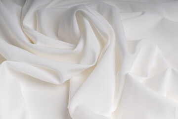 Minimalist white background made of soft fabric with beautiful folds.