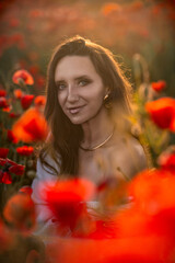 Woman with long hair smiles in poppy field.
