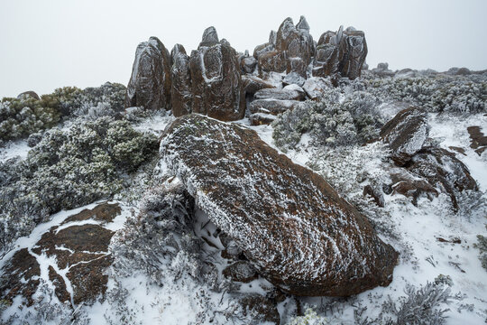 Jagged rock formations covered in rime ice and surrounded by winter snow