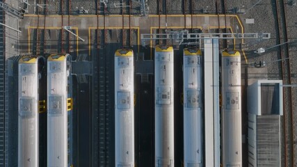 Aerial view of train cars at a maintenance facility in Auckland, New Zealand. The train cars are being inspected and repaired to ensure they are safe and reliable for passengers.