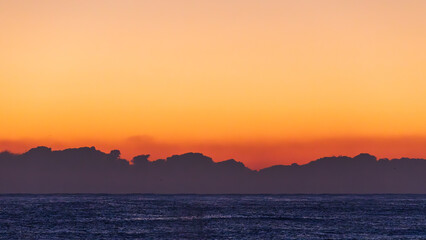 Low Cloud Silhouettes Above the Sea Horizon Before Sunrise