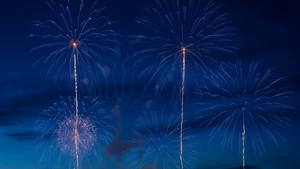 Vibrant blue fireworks exploding in night sky with sparkling trails