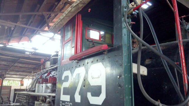 Old steam train in a rustic shed, number 279 visible on side