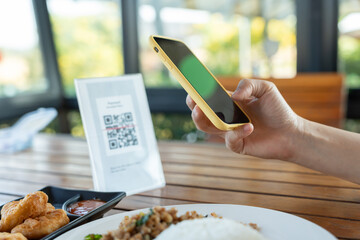 Woman use smartphone to scan QR code to pay in cafe restaurant with a digital payment without cash. Choose menu and order accumulate discount. E wallet, technology, pay online, credit card, bank app.