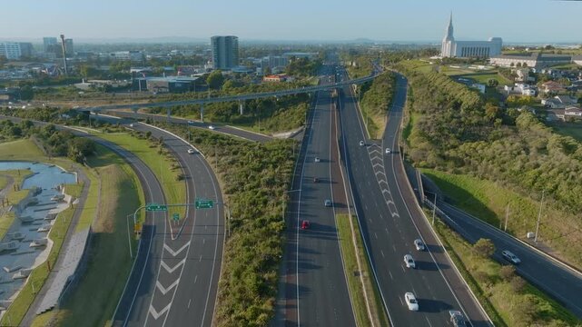 Aerial view of cars driving on a highway in Auckland, New Zealand. The Auckland New Zealand Temple is visible in the background. Manukau City.