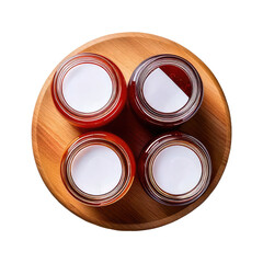Four jars of preserves sit on a wooden platter