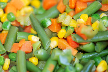 Roasted corn, green beans, carrots and peas, authentic vegetable stir fry full frame backdrop.