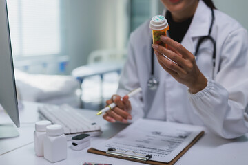 Doctor holding medication bottle reviewing prescription information