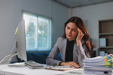 Businesswoman feeling stressed and having a headache at office