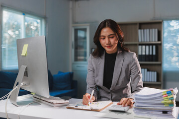 Asian businesswoman analyzing financial data working overtime desk