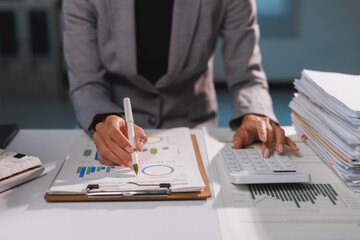 Businesswoman analyzing financial data and calculating business expenses