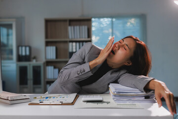 Young businesswoman yawning experiencing work exhaustion and fatigue