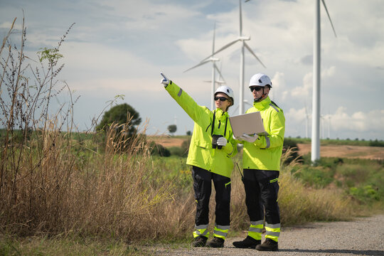 Renewable energy maintenance planning wind farm professional meeting open field ground level collaboration on sustainability
