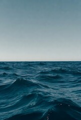 The immense and tranquil beauty of the deep blue ocean, with gentle waves creating a rhythmic pattern under a soft, expansive sky, evoking a sense of calm and natural power and endless serenity