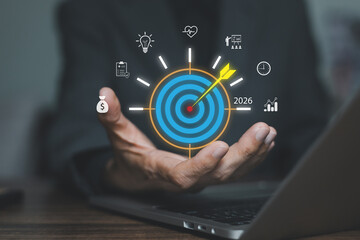 Businessman hand holding virtual 2026 target board. Concept of business goal setting, future strategy planning, marketing vision, objective achievement, and financial success.