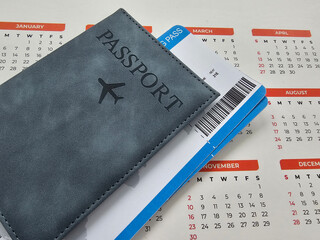 Planning a trip with a passport and travel ticket on a calendar concept