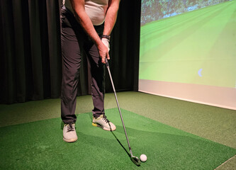 Indoor golf practice with a simulator, focusing on swing technique and aiming skills at a training facility concept