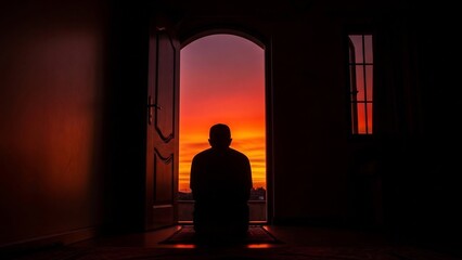 Silhouette of a Person Standing in a Doorway with a Vibrant Sunset View.