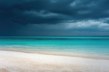 Fototapeta premium Turquoise ocean meets white sandy beach under a dramatic, stormy sky