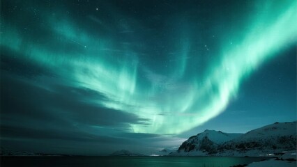 Naklejka premium Aurora borealis illuminates the night sky over a snowy mountain landscape near a calm body of water