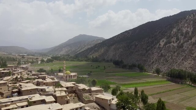 Drone aerial of charming rural scenery of Zazai Aryub Paktia, Afghanistan with its historic mud village in the lush farmlands between Hindu Kush mountains