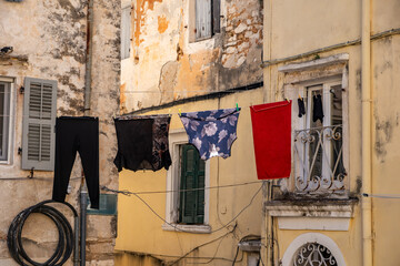 Laundry hangs above the alley in Corfu old town, Greece. Traditional architecture buildings.