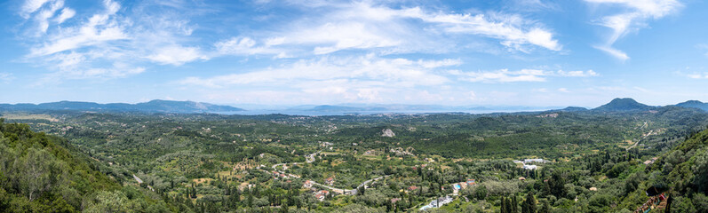 Panoramic view from Kaiser's Observatory in Pelekas, Corfu Greece. Green hills, small villages and distant sea, blue sky