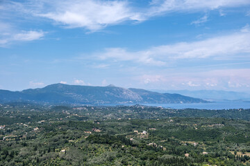 View from Kaisers Observatory in Pelekas, Corfu island, Greece. Lush green hills, scattered villages and the distant Ionian Sea