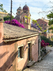 Corfu island old town. Monastery of Panagia Tenedos on a cobblestone alley. Church bell Tower, Greece. .