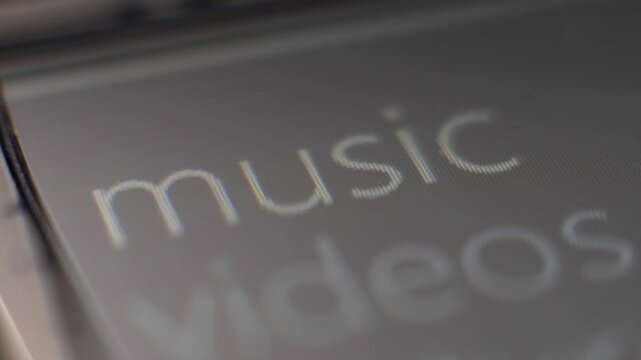 Macro view of vintage device menu scrolling through music, videos and pictures