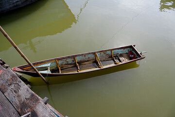 Traditional Wooden Boat Moored on Calm Green Water,