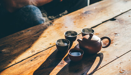 Cozy tea set on rustic wooden table with warm sunlight