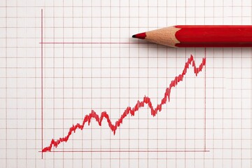 A red pencil draws an upward trending graph on graph paper