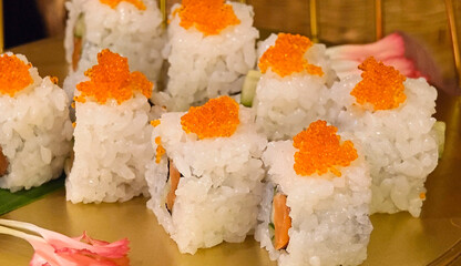Delicious, fresh  sushi with bright orange tones presented on a traditional Japanese plate. © siriratsavett88