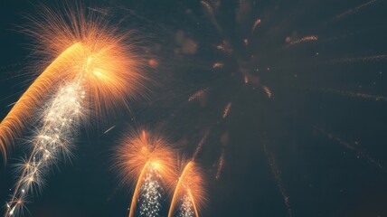 Bright golden fireworks exploding in the night sky with white sparks and trails
