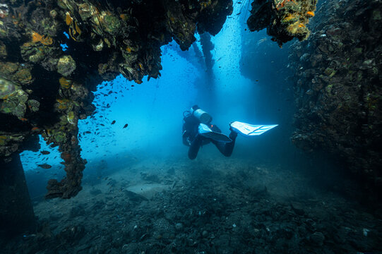 Scuba diver exploring the HTMS Chang wreck in  the gulf of Thailand